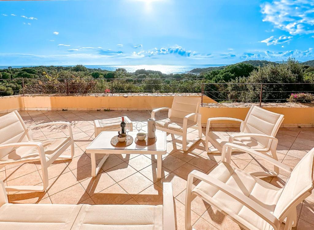 un patio avec une table et des chaises sur un toit dans l'établissement Villa Clementina, à Sainte-Lucie de Porto-Vecchio