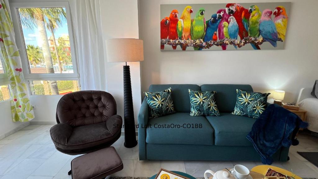 salon z niebieską kanapą i krzesłem w obiekcie Primera línea playa Apart 1 Bed CostaOro-CO1BA DELUXE Seafront ó Loft-Studio CostaOro-CO1BB STANDARD w mieście Torrox Costa
