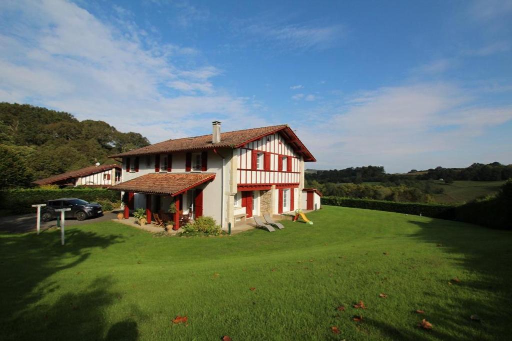 a house in a field with a green yard at Errotalde-berria in Sare