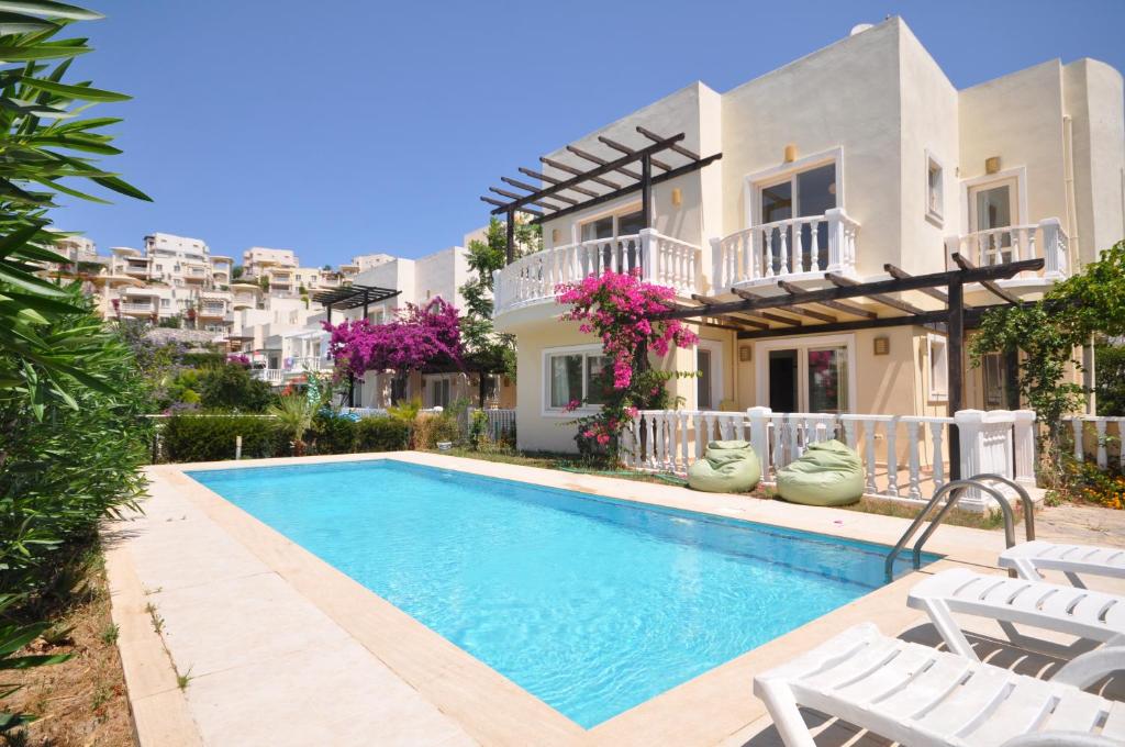 a villa with a swimming pool in front of a house at Villa Romantica 17 in Milas