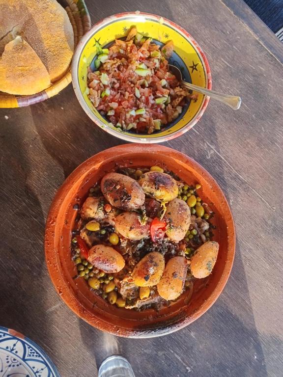 two bowls of food on a wooden table at EL Faro Surfstay in Tamri