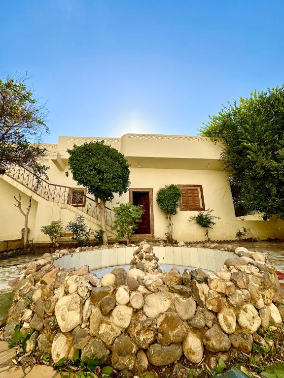 a house with a pile of rocks in front of it at Sunset Haven Guesthouse in Luxor