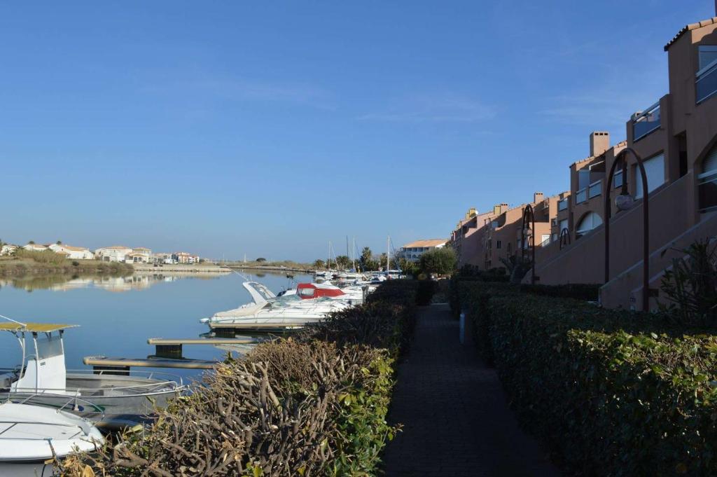 un trottoir à côté d'un port de plaisance avec des bateaux dans l'eau dans l'établissement Appartement 2 pièces cabine 6 personnes SAINT CYPRIEN SC150-138, à Saint Cyprien Plage