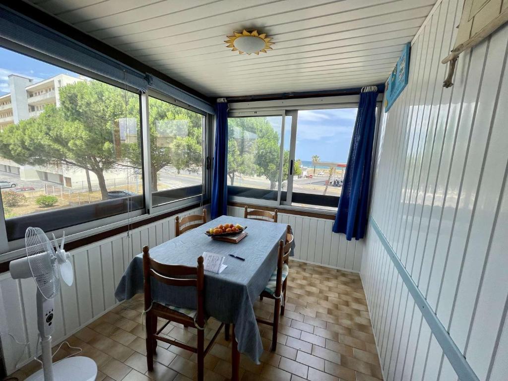 - une table avec une assiette de nourriture dans une pièce dotée de fenêtres dans l'établissement Appartement 2 pièces cabine 4 couchages ST CYPRIEN PLAGE SC510-95C, à Saint Cyprien Plage