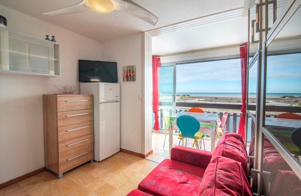 - un salon avec un canapé rouge et une grande fenêtre dans l'établissement Appartement Studio cabine 4 couchages ST CYPRIEN PLAGE SC270-039, à Saint Cyprien Plage