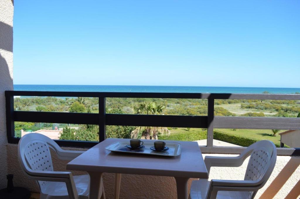une table et des chaises sur un balcon avec vue sur l'océan dans l'établissement appartement 2 pièces mezzanine 6 couchages ST CYPRIEN PLAGE SC490-022, à Saint Cyprien Plage