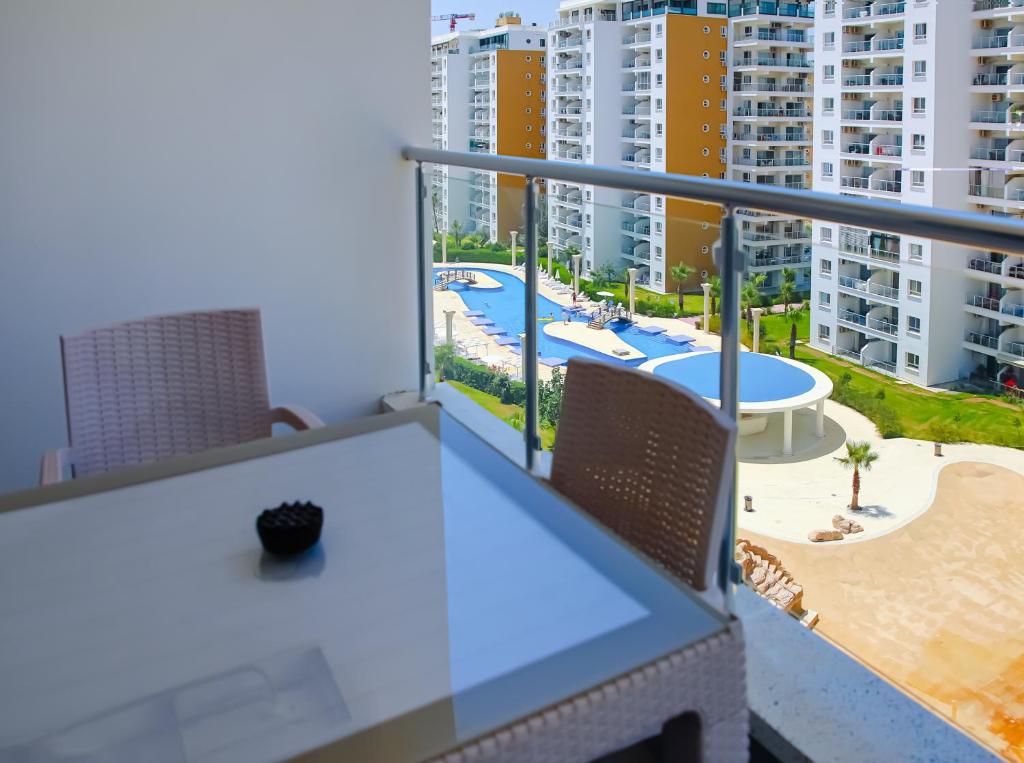 a balcony with a table and chairs and buildings at Cornelius Cosy Apartments in Caesar Resort & SPA in Perivolia tou Trikomou