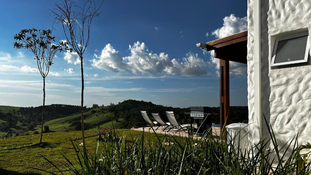 a group of chairs sitting next to a house at Casa Mediterrânea no alto da montanha in Itu