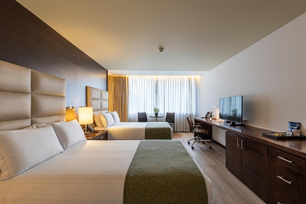 Кровать или кровати в номере Hotel Estelar Milla De Oro