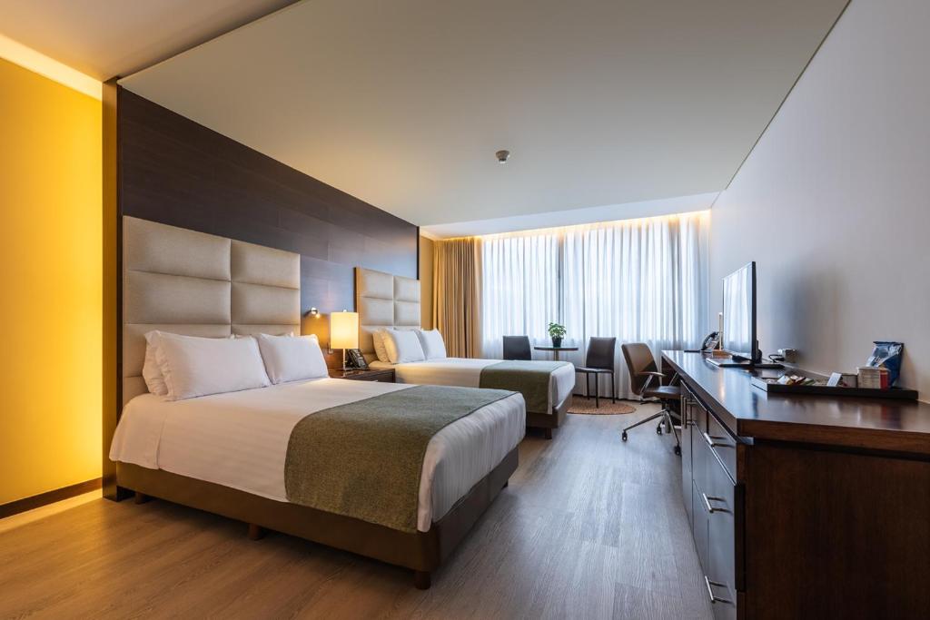 Кровать или кровати в номере Hotel Estelar Milla De Oro