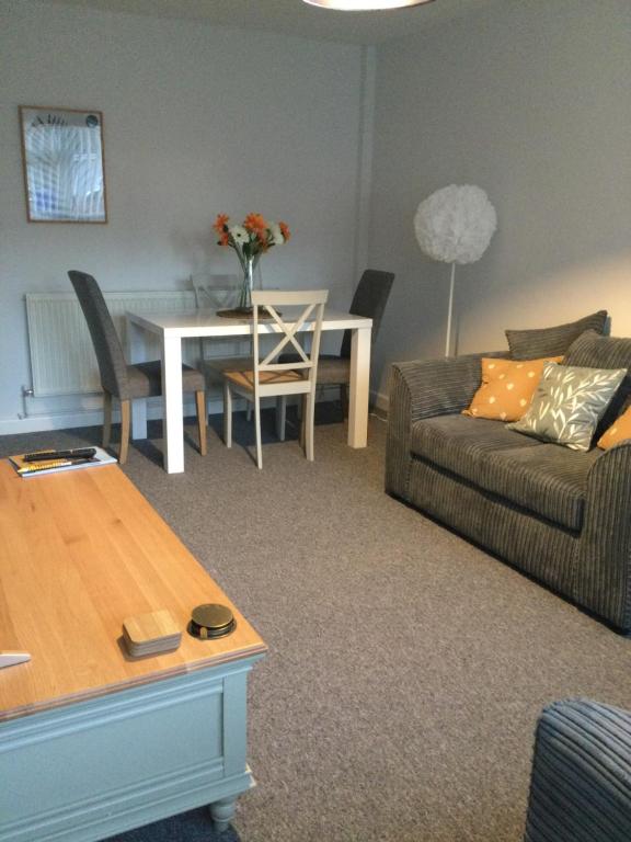 a living room with a couch and a table at Light and airy cosy bungalow in Draycott