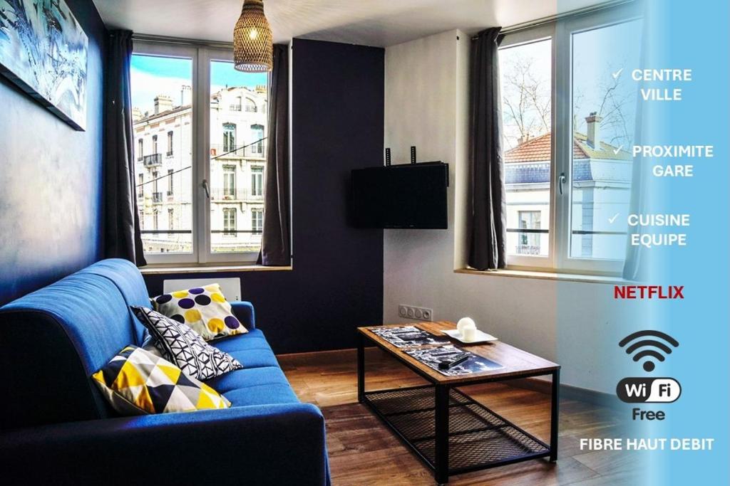 un salon avec un canapé bleu et une table dans l'établissement La cité des affaires, à Saint-Étienne