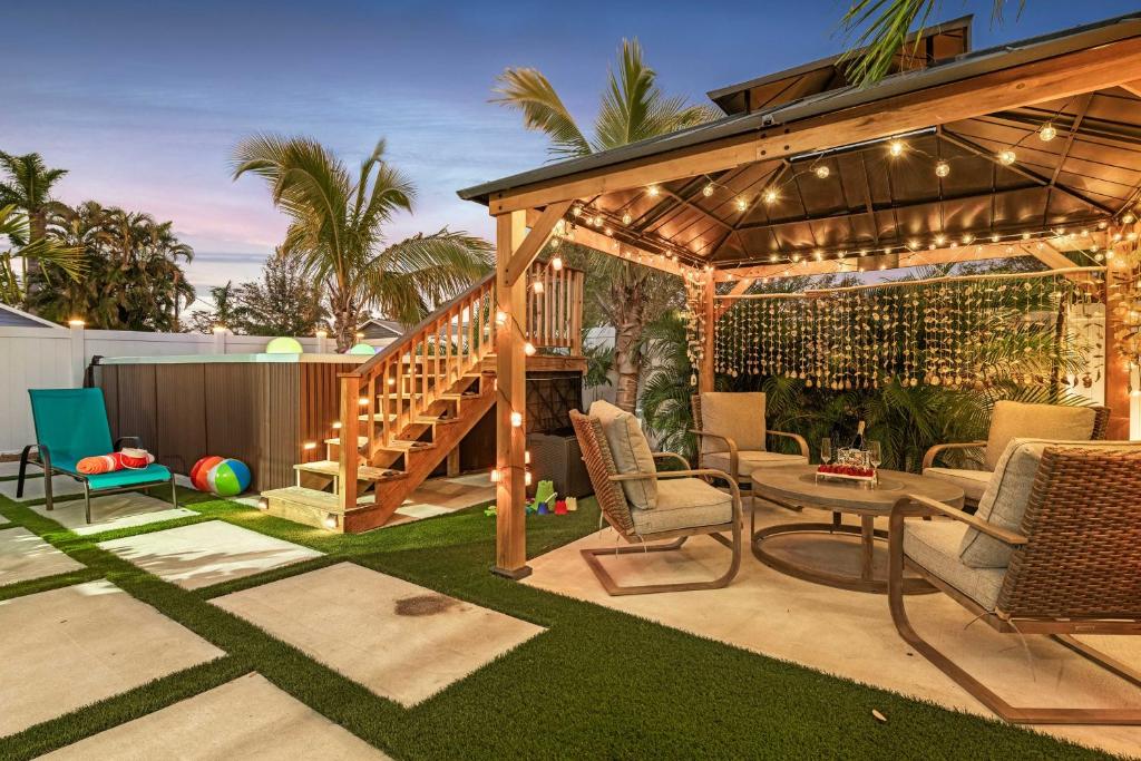 a patio with a wooden pergola with chairs and a table at Heated Pool, Mini Golf and Cabana Bradenton Retreat in Bradenton