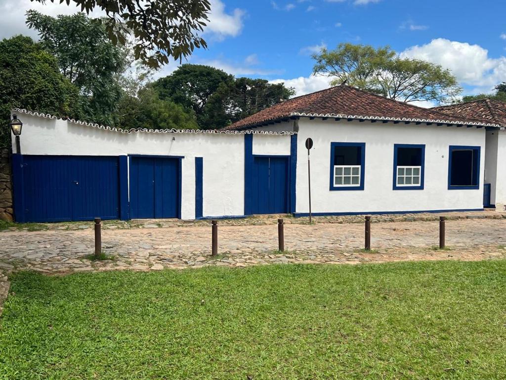 ein weiß-blaues Haus mit blauen Türen in der Unterkunft Casa no Chafariz in Tiradentes
