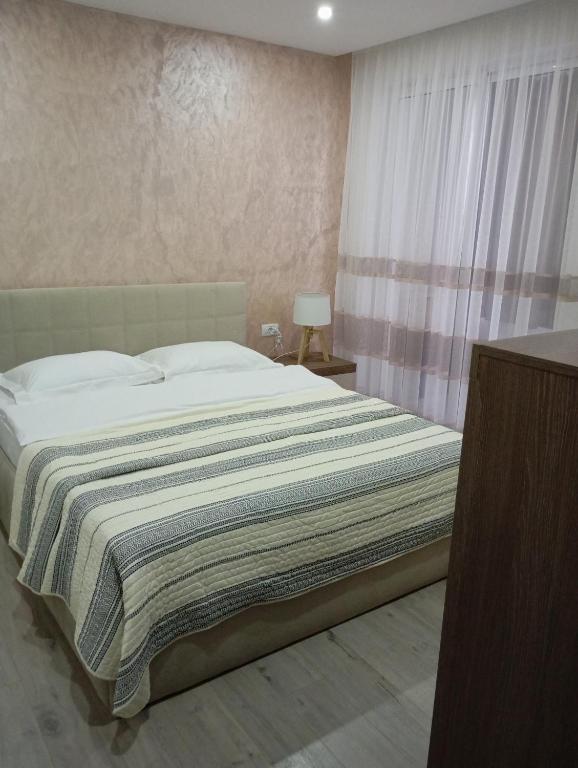 ein Schlafzimmer mit einem Bett und einem Tisch mit einer Lampe in der Unterkunft Apartament Ultimul Leu in Galaţi