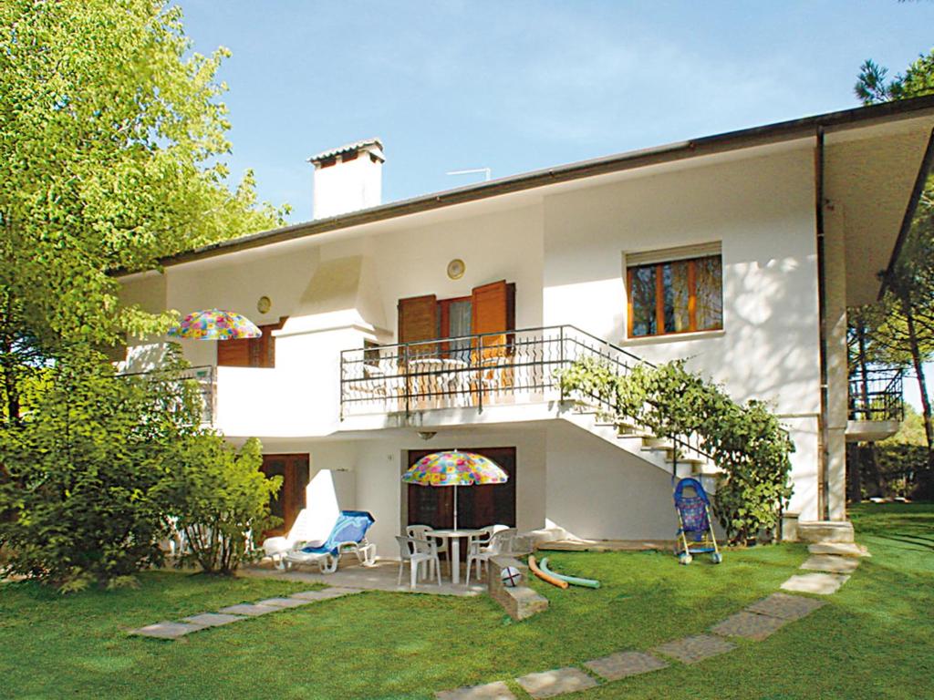 Casa blanca con balcón y patio en Lignano Riviera, en Lignano Sabbiadoro