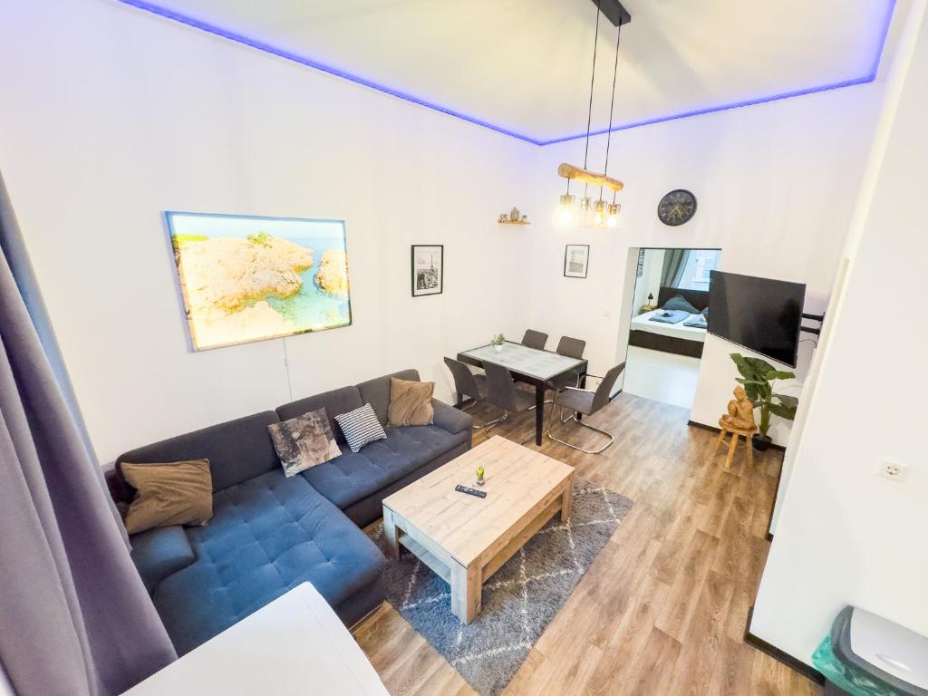a living room with a blue couch and a table at #221 Moderne City Wohnung im Herzen von Neuss in Neuss