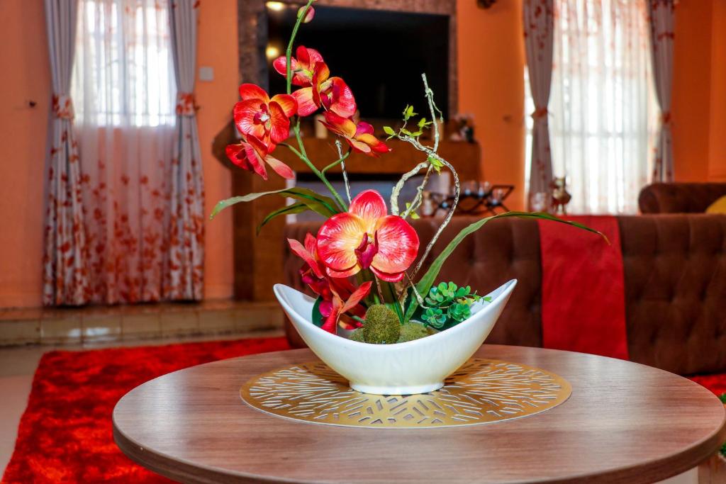 Eine Vase mit Blumen auf einem Tisch in der Unterkunft C & G house in Nairobi