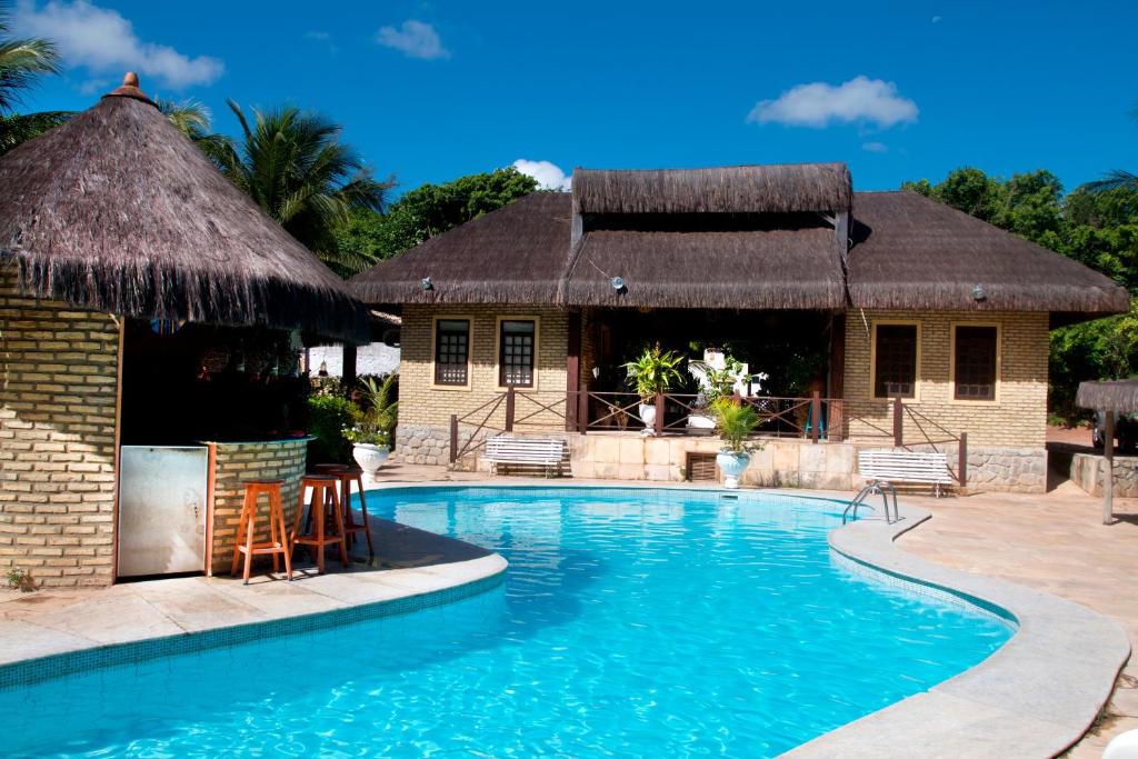 um resort com uma piscina e uma cabana em Pousada Império do Sol em Pipa