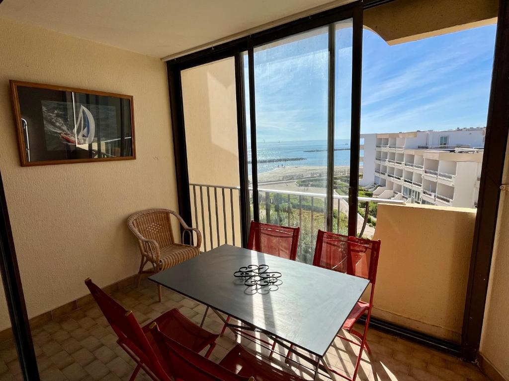 d'une table et de chaises sur un balcon avec vue sur l'océan. dans l'établissement Horizon Nostrum YourHostHelper, à Palavas-les-Flots