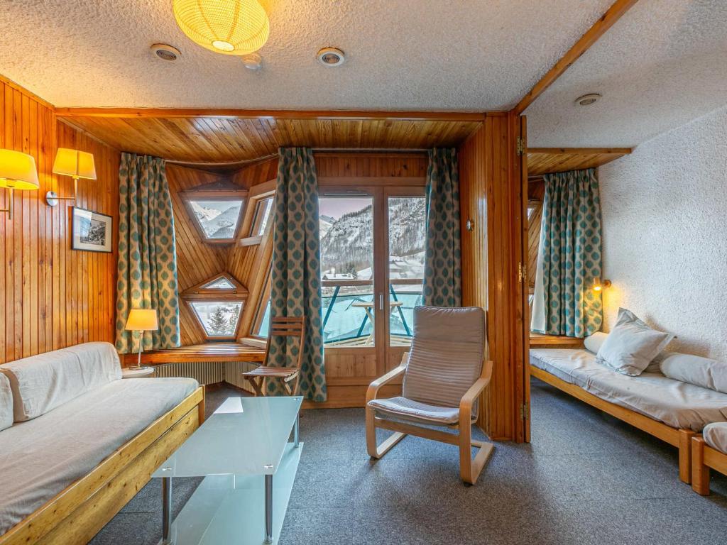 une chambre avec deux lits et une chaise et une fenêtre dans l'établissement Appartement alpin cosy, 2 chambres, 2 salles de bain, balcon sud et skis aux pieds à La Daille - FR-1-694-256, à Val dʼIsère