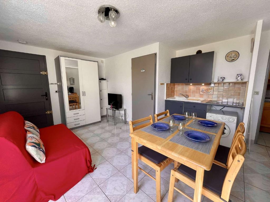 un salon avec une table et un canapé rouge dans l'établissement Appartement 2 pièces 4 couchages ST CYPRIEN PLAGE SC510-172I, à Saint Cyprien Plage