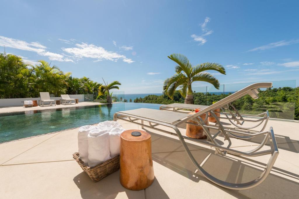 una piscina en el complejo con una mesa y sillas en un patio en Casa Phil - Amazing Sea View Luxury Modern, Fully Staffed, en Las Terrenas