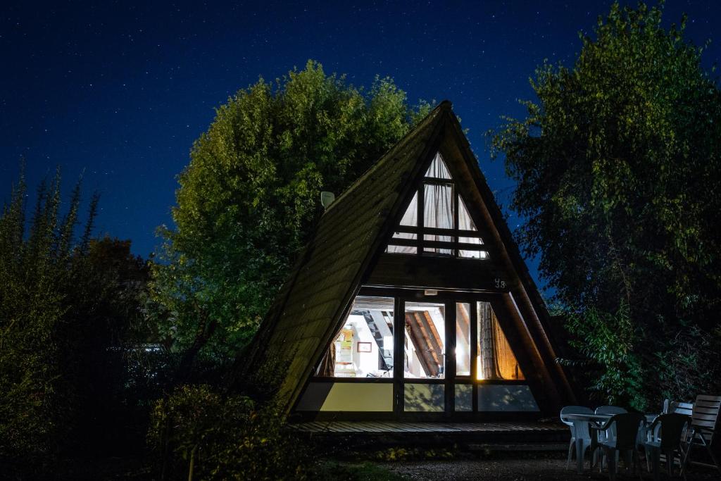 a frame house with a glass window at night at Bodensee Häusle in Immenstaad am Bodensee