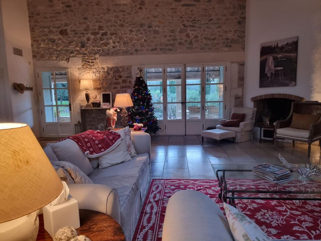 un salon avec un arbre de Noël en arrière-plan dans l'établissement Magnifique villa à Montaud, à Montaud