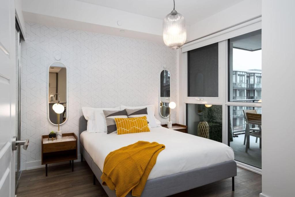 a bedroom with a bed with a yellow blanket on it at Amazing 2BR 2BA Resort Condo w Balcony and Parking in Barrie