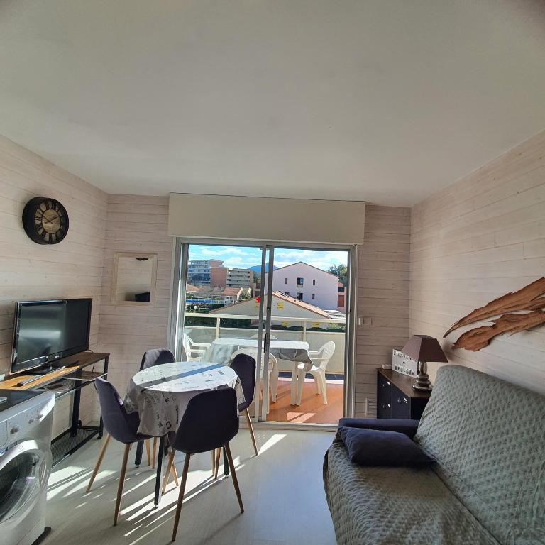 un salon avec un lit, une table et des chaises dans l'établissement Studio 4 pers Résidence le petit bois à 300 m de la plage, à Argelès-sur-Mer