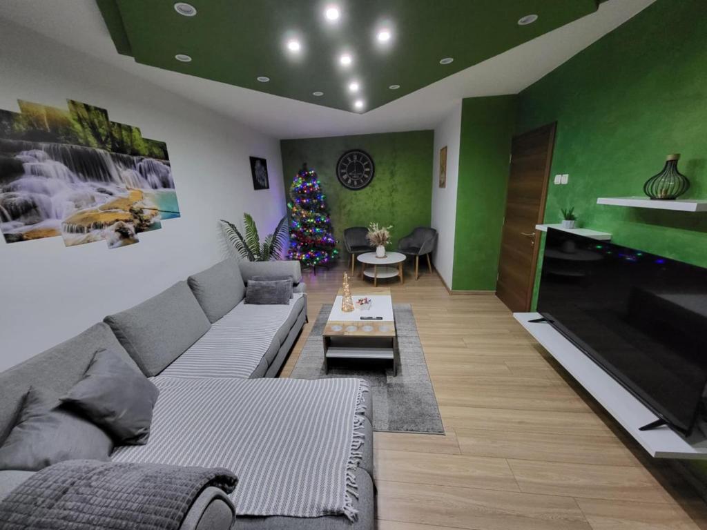 a living room with a couch and a christmas tree at Aby in Slavonski Brod