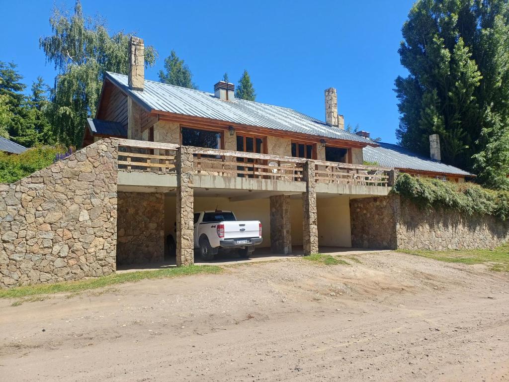 a house with a car parked in front of it at Cabaña Las Aljabas 1 in San Martín de los Andes