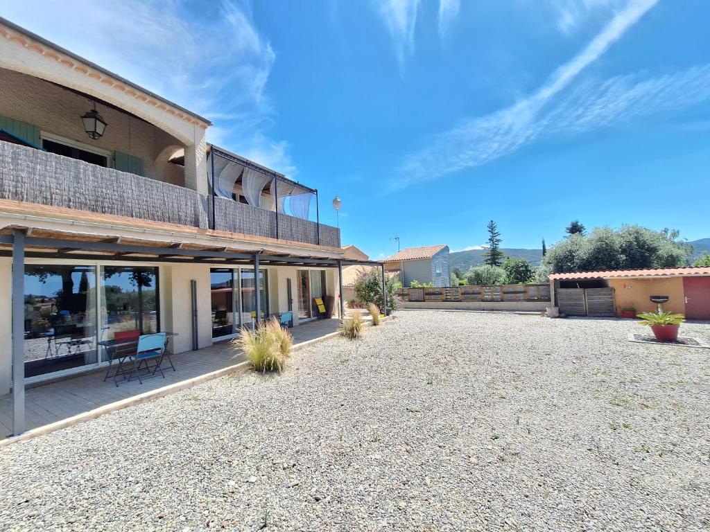 une cour vide d'un bâtiment avec une terrasse dans l'établissement Association Vita'vie La Villa, à Peyruis