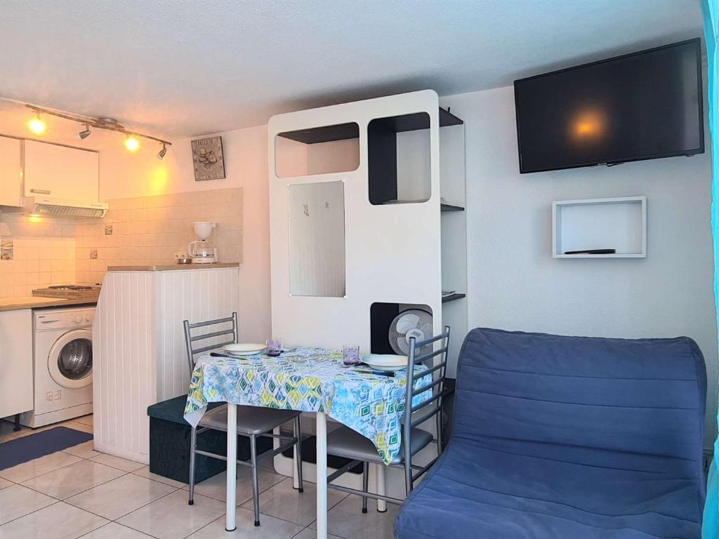 d'une petite cuisine avec une petite table et des chaises. dans l'établissement Appt Studio 3 couchages CAP D 'AGDE CT150-H101, au Cap d'Agde