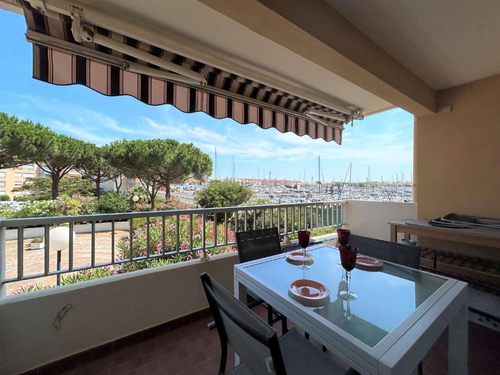 - un balcon avec une table et deux verres de vin dans l'établissement Appartement 2 pièces CAP D 'AGDE CT160-013, au Cap d'Agde