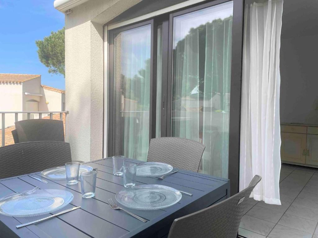 une table bleue avec des plaques sur le balcon dans l'établissement Appartement 3 pièces - Le Cap D'Agde CT210-134, au Cap d'Agde