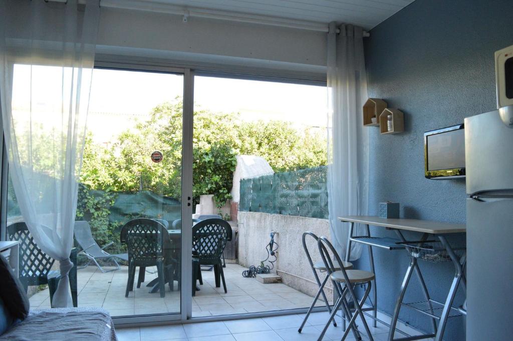 Cette chambre dispose d'une terrasse avec une table et des chaises. dans l'établissement Studio cabine Le Grau d'Agde CT245-002, au Grau-dʼAgde