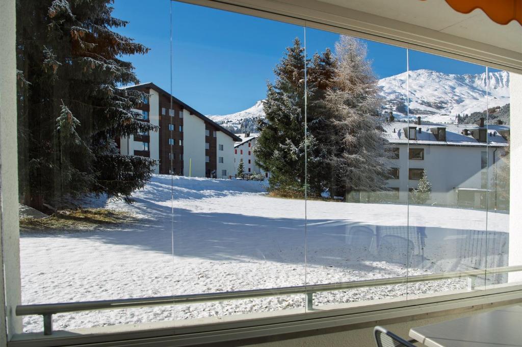 a window with a view of a snow covered yard at Apartment right next to ski lift in Parpan