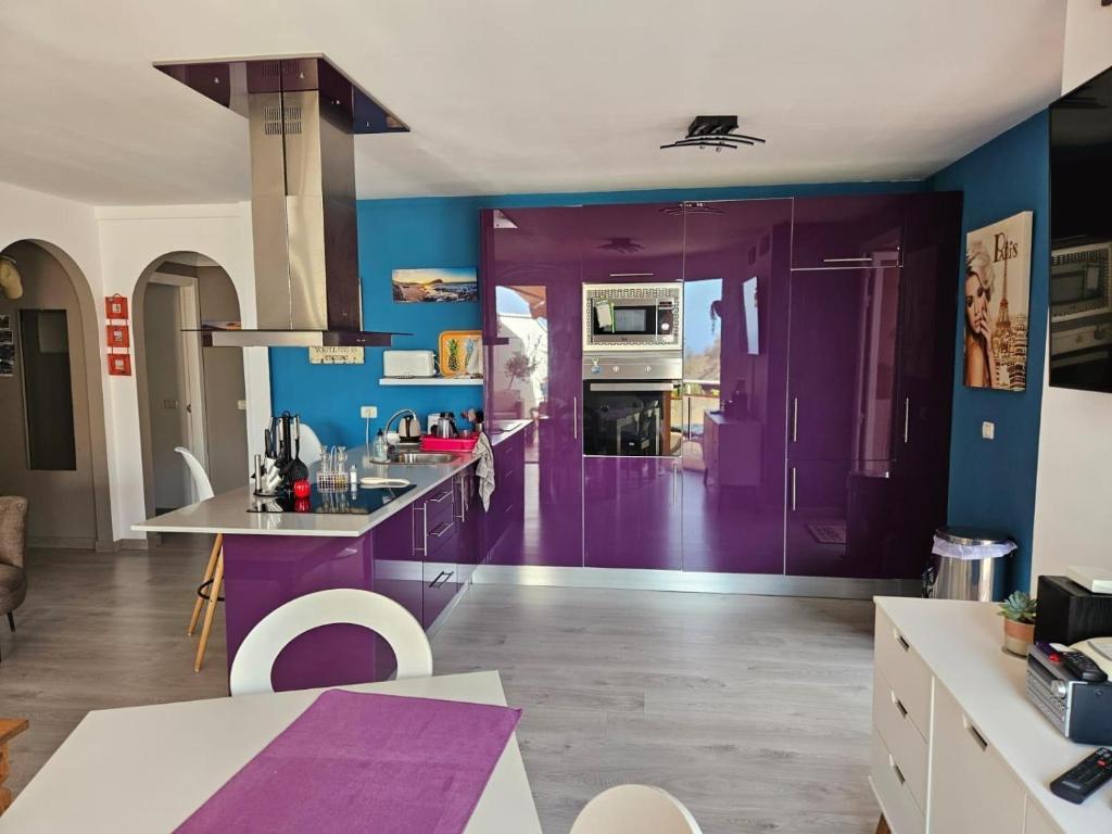 une cuisine avec des placards violets et des murs bleus dans l'établissement Ocean View The Sunset, à Adeje