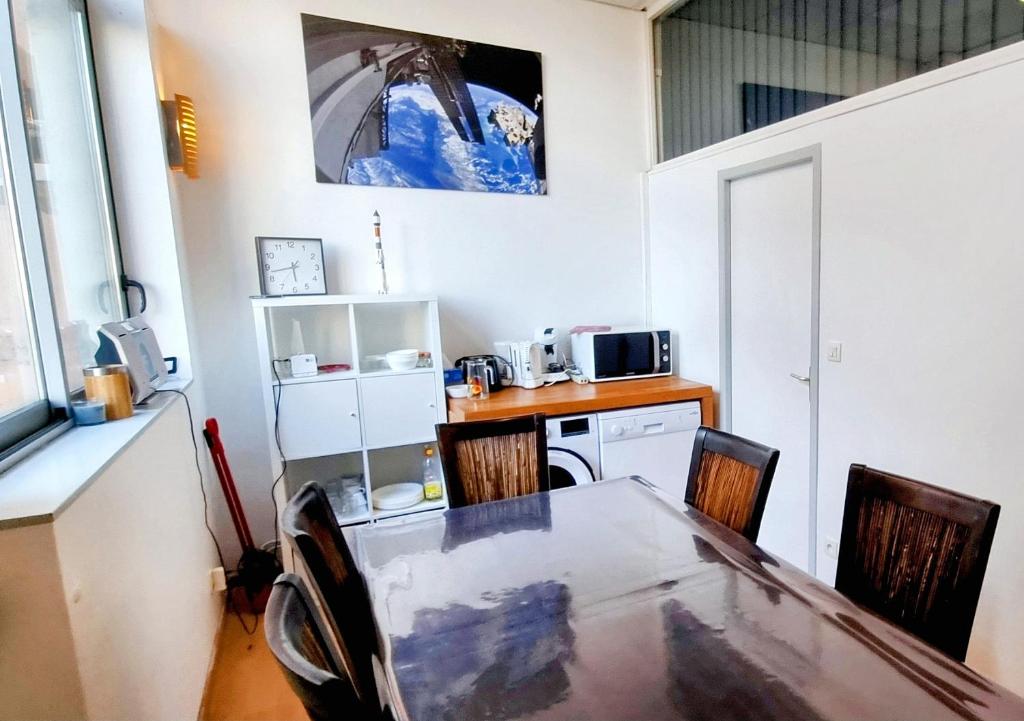 une cuisine avec une table et des chaises et un micro-ondes dans l'établissement Spacieux T2 Bis Industriel Aérospatial, à Toulouse