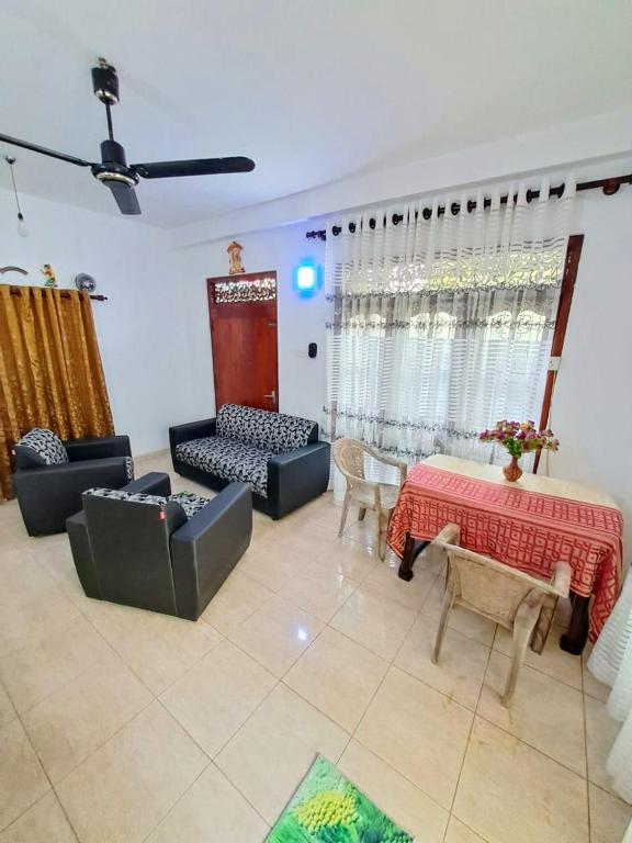 a living room with a couch and a table and chairs at Monara Villa in Hikkaduwa