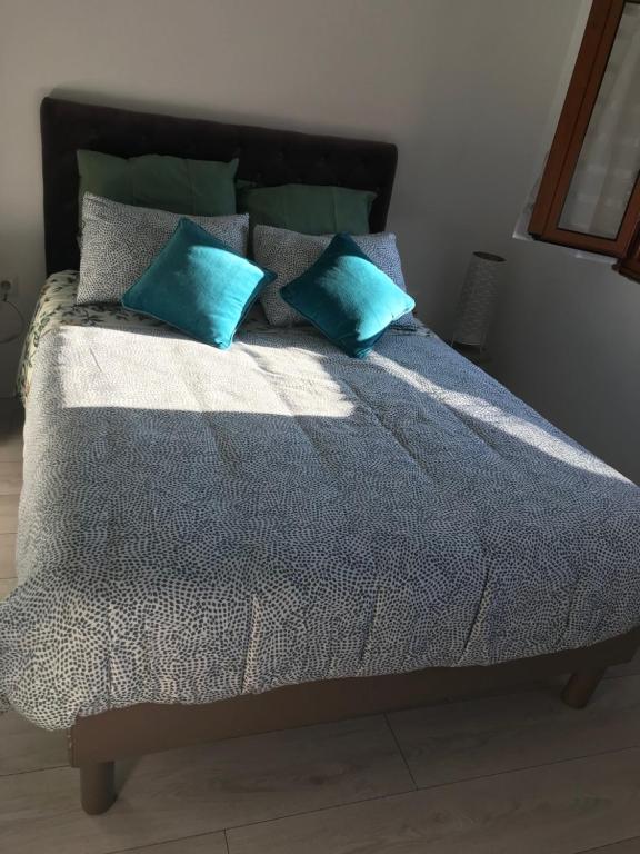 a bed with two blue pillows on top of it at Casa do Sino in Arcos de Valdevez