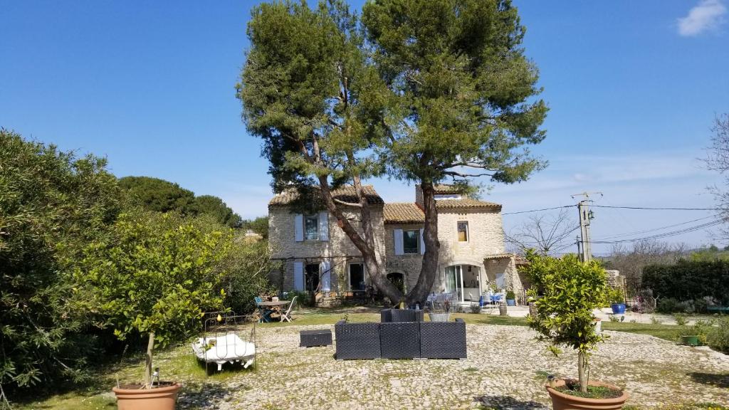 une maison avec un grand arbre en face dans l'établissement Bastide des Calades, à Lançon-Provence