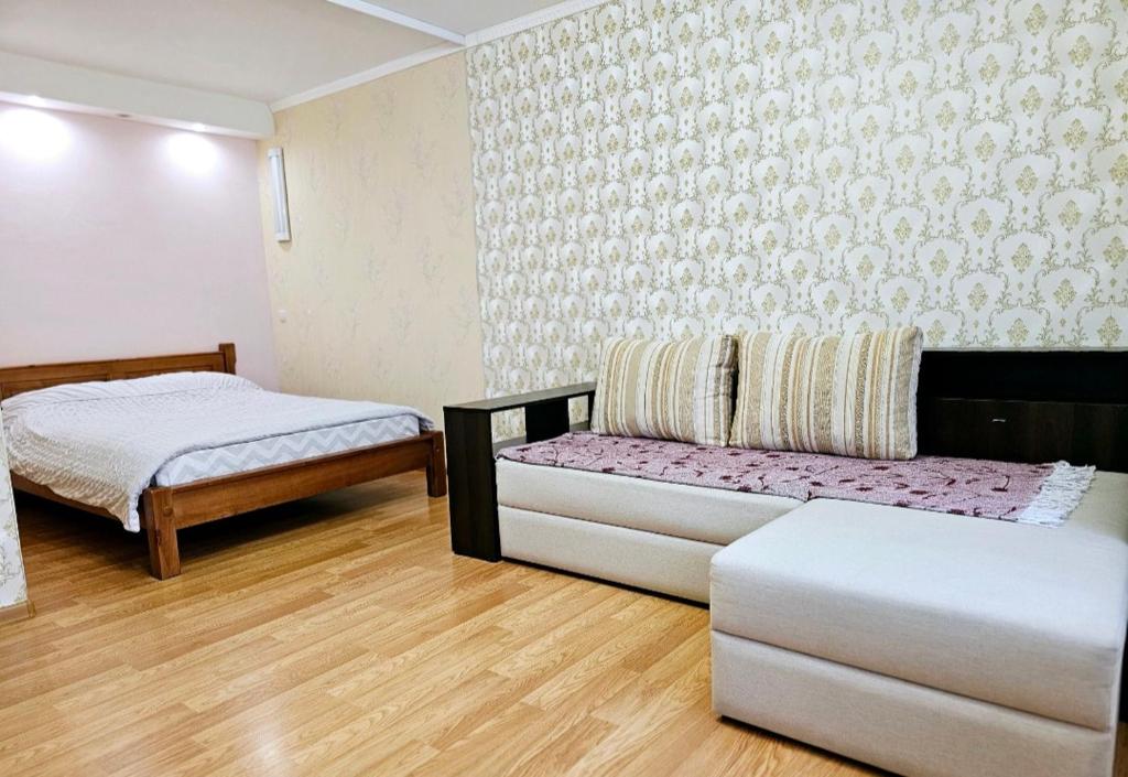 ein Zimmer mit 2 Betten und einem Sofa darin in der Unterkunft 1 комнатня квартира на ул Яскрва 7, клиника Рохманова, , пр Слобожанский, 6 городская клиника in Nizhnedneprovsk