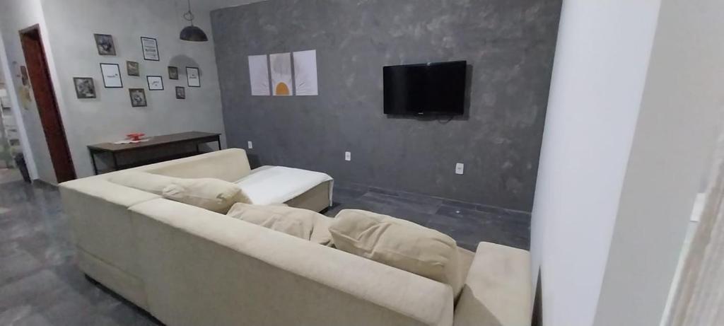 ein Wohnzimmer mit Sofa und Fernseher in der Unterkunft Casa de praia com piscina em Governador Celso Ramos in Governador Celso Ramos