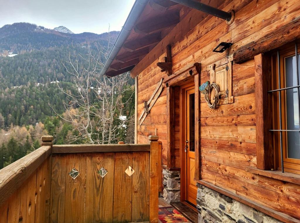 a wooden cabin with a porch and a door at La Comba - Les Fleurs in Cerise