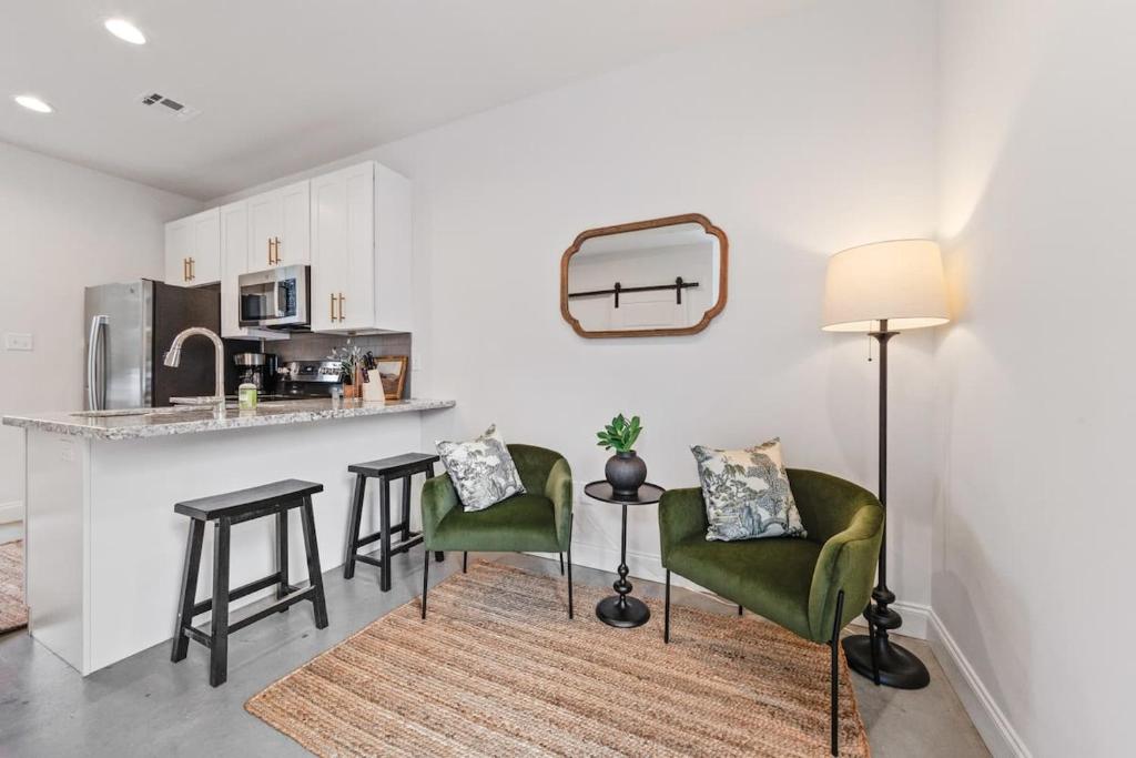 a kitchen with two green chairs and a counter at Charming Townhome - New Construction in Lafayette