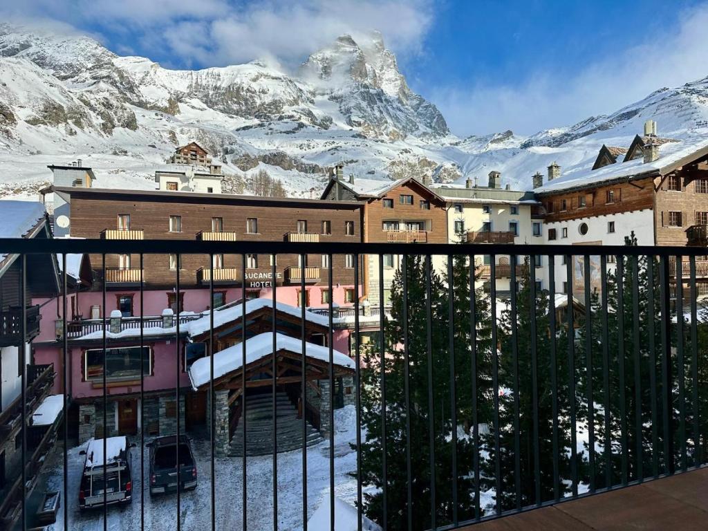 Blick auf ein Gebäude mit einem schneebedeckten Berg in der Unterkunft MCX Vacation Rental - Maison Cian, Appartamento con balconi panoramici nel cuore di Breuil Cervinia in Breuil-Cervinia