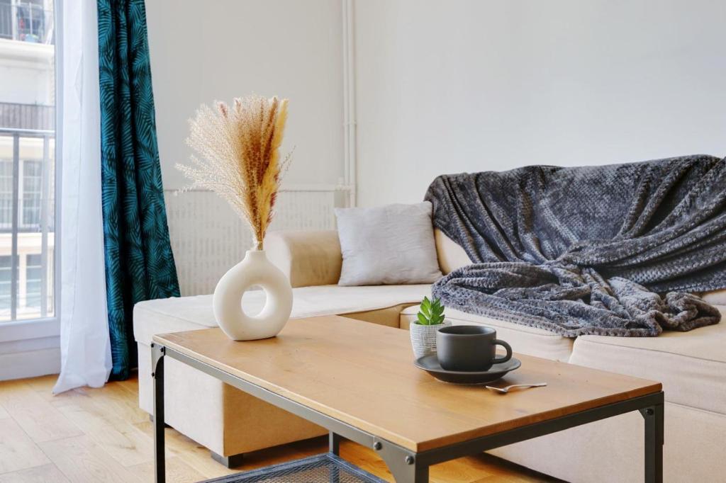 - un salon avec un vase sur une table basse dans l'établissement Au pied de l'arche de la défense, à Courbevoie